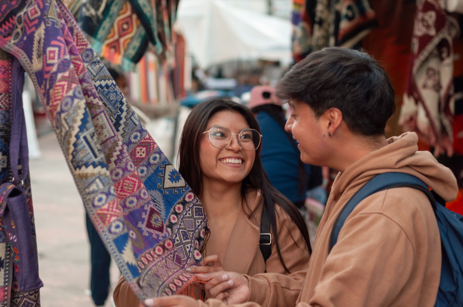 Joyful couple shares a moment of excitement while browsing beautiful textile crafts