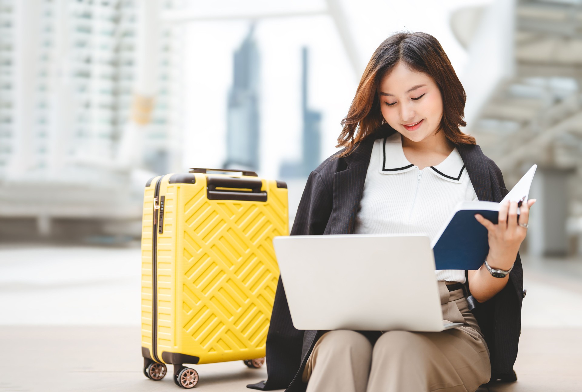 Business travel asian woman using laptop computer sitting at outdoor on day